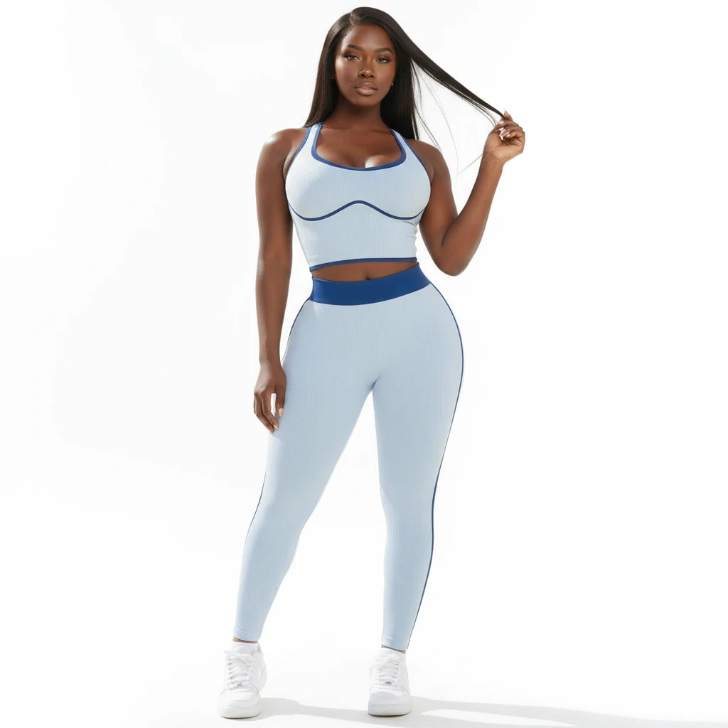Model wearing a Swerves & Curves Boutique baby blue ribbed two-piece workout set with dark blue trim and leggings.