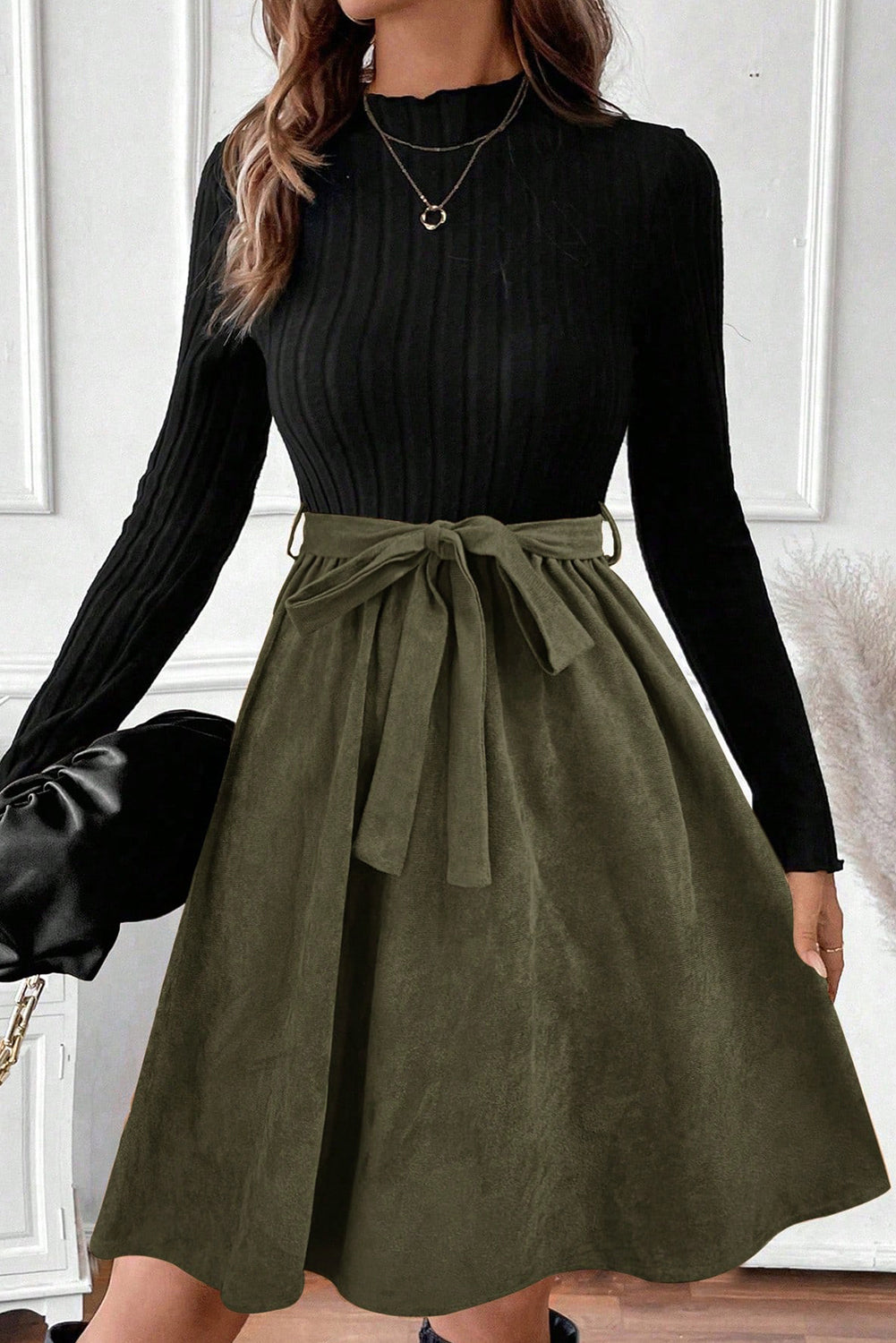 Swerves & Curves Boutique black ribbed knit mock neck bodice dress with an olive green flared skirt and tie belt.