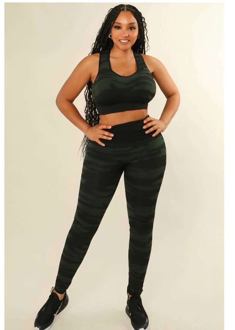 Model wearing a Swerves & Curves Boutique dark green camo two-piece workout set with a sports bra and leggings.
